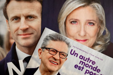 This picture taken on April 6, 2022 in Marseille, southern France, shows folded electoral leaflets of French President and liberal party La Republique en Marche (LREM) candidate for re-election Emmanuel Macron (L), French leftist party La France Insoumise (LFI) presidential candidate Jean-Luc Melenchon (C) and French far-right party Rassemblement National (RN) presidential candidate Marine Le Pen ahead of the first round of the French presidential election. 