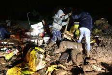 Picture released by Ecuadorean agency API showing people removing debris during the search of victims after a landslide caused by heavy rains in Quito, on January 31, 2022.