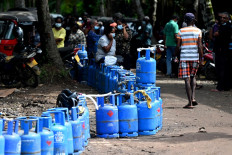 People queue to buy Liquefied Petroleum Gas (LPG) cylinders in Colombo on April 11, 2022.
