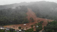 This aerial photo shows the collapsed mountain side and buried houses in the village of Bunga, Baybay town, Leyte province, in southern Philippines on April 12, 2022, a day after a landslide slammed into the village due to heavy rains brought about by tropical storm Megi. 