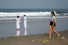 Balinese take part in a Melasti prayer ceremony, Hindu purification festival, at Petitenget beach near Seminyak on Indonesia's resort island of Bali on February 28, 2022. 
