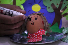 Easter mood: A student decorates an Easter egg at the Widya Tama school for children with special needs in Surabaya, East Java, on April 14, 2022.