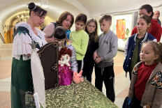 Children watch puppeteer Oleksandra Shlykova (L) as she performs at the metro stations of Kharkiv, eastern Ukraine, on April 16, 2022.