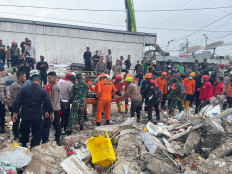 This handout photo released by Indonesia's national search and rescue body BASARNAS on April 19, 2022 shows rescue personnel evacuating victims from the scene of a minimarket building which collapsed on April 18 in Martapura, Banjar regency, South Kalimantan. A minimarket building in Indonesia collapsed, killing five shoppers and injuring nine others, officials said on April 19.