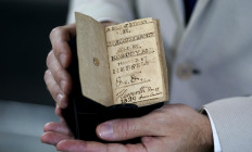 Tiny treasure: A staffer shows the miniature, unpublished manuscript titled A Book of Ryhmes [sic] by Charlotte Bronte, Sold by Nobody, and Printed by Herself, written by English novelist and poet Charlotte Bronte, on Thursday at the New York Antiquarian Book Fair in New York.