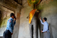 Slow revival: APSARA Authority spokesman Long Kosal (right) gestures on April 7 as a security guard looks on at the Angkor Wat temple complex, a UNESCO World Heritage Site, in Siem Reap, Cambodia.