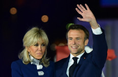 French President Emmanuel Macron and his wife Brigitte Macron celebrate after his victory in France's presidential election, at the Champ de Mars in Paris, on April 24, 2022. 