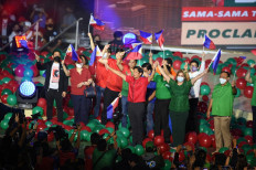 Bongbong Marcos (front left, in red), presidential candidate and son of the late dictator Ferdinand Marcos, and his Vice-Presidential candidate Sara Duterte (front R, in Green), daughter of incumbent President Rodrigo Duterte, raise their hands during a campaign rally inside a gymnasium in Bocaue town, Bulacan province, north of Manila on February 8, 2022. 