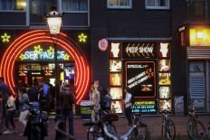 Flagging dangerous clients: People walk in the red-light district of Amsterdam on July 1, 2020 as Dutch brothels reopen following a long coronavirus shutdown. On April 20, the Netherlands launched Ugly Mugs NL, a new online platform to protect sex workers from dangerous clients.