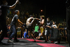 This photo taken on April 16, 2022 shows combatants competing in Muay Thai at an event by Fight Club Thailand in a parking lot in the Klong Toey district of Bangkok.