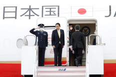 Japan's Prime Minister Fumio Kishida (center) prepares to board his flight to Indonesia at Tokyo's Haneda International Airport on April 29, 2022. 