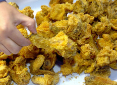 A South Korean holds a fried chicken during a campaign to promote chicken sales in Seoul, 01 December 2005. The price of chicken meat is plunging in South Korea due to a worldwide avian influenza scare. 