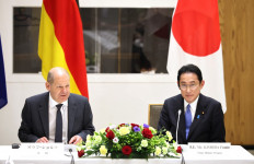 German Chancellor Oraf Scholz (left) delivers a speech before Japanese and German business leaders while Japanese Prime Minister Fumio Kishida (right) looking on after Japan-Germany summit talks at the prime minister's official residence in Tokyo on April 28, 2022. 