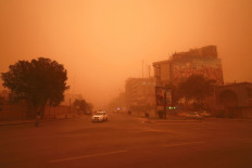 Vehicles drive along a road during a severe dust storm in Iraq's capital Baghdad on May 1, 2022.