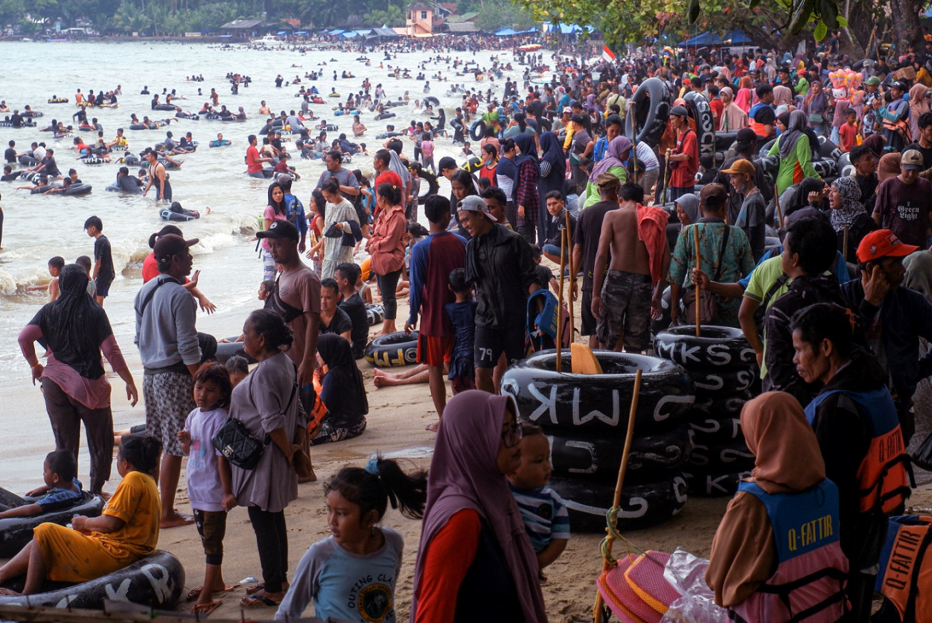 Indonesians enjoy the long Idul Fitri holidays with their families at a beach in Banten on May 4.