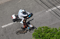 A policeman wearing protective gear on a scooter speaks with a woman on a street during the COVID-19 coronavirus lockdown in the Jing'an district of Shanghai on May 6, 2022.