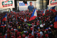 Supporters of presidential candidate Ferdinand Marcos Jr., son of the late dictator Ferdinand Marcos, and his running mate Sara Duterte, daughter of President Rodrigo Duterte, wave flags during a campaign rally in Paranaque City, suburban Manila on May 7, 2022, days ahead of the May 9 presidential election. 