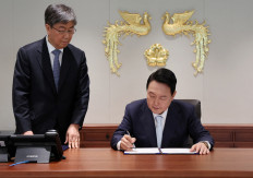 South Korea's new President Yoon Suk-yeol signs a document as he works at the new Presidential office in Seoul, South Korea, May 10, 2022. 