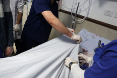 A medical worker covers the body of veteran Al Jazeera journalist Shireen Abu Aqleh, who was shot dead by Israeli troops as she covered a raid on the West Bank's Jenin refugee camp on May 11, 2022, at the hospital in Jenin. 