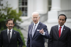 Flanked by Sultan of Brunei Hassanal Bolkiah (left) and Indonesian President Joko "Jokowi" Widodo (right), United States President Joe Biden reacts to a reporter's question during a family photo for the US-ASEAN Special Summit on the South Lawn of the White House on May 12 in Washington, DC.