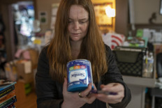 A program coordinator at Mother & Child Education Center checks the lot number on a donated can of baby formula against a list of recalled cans in Portland, Oregon, US, on May 12, 2022. Many NGOs are struggling to meet increased demand from mothers who are unable to find or afford formula in stores.
