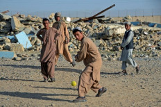 Sports time: Boys play cricket in front of a school that was damaged during the conflict between the Taliban and Afghanistan's former ruling government, in Kandahar on May 12, 2022. 