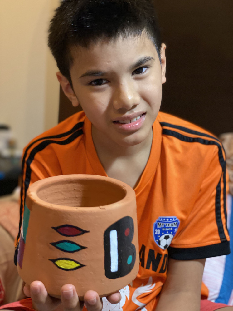 Remarkable artwork: Abhiyasa Adhi Pradhanika poses with his finished clay pot. (Courtesy of Adhyanti Sardanarini)