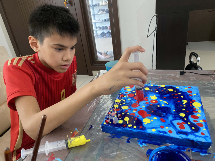 Exploring space: Abhiyasa Adhi Pradhanika, 13, who was diagnosed with autism at the age of 6, works on 'The Galaxy', which recently featured in Jakarta-based VOCA’s “Through My Window: An Exhibition by Neurodivergent Artists” virtual exhibition on Kunstmatrix. (Courtesy of Adhyanti Sardanarini)