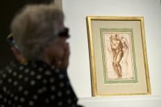 People sit during the auction of a recently rediscovered drawing by Michelangelo, the artist's first known nude, at the Christie's auction house in Paris on May 18, 2022.