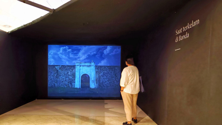 Past horrors: A visitor watches a slideshow telling of the darkest moments in the history of the Banda Islands, which was colonized by the Dutch for two centuries, at Isabella Boon’s “I Love Banda” photography and multimedia exhibit at Erasmus Huis Jakarta. (JP/Sylviana Hamdani)