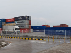 A truck passes containers stacked up at the Hyundai electric car assembly plant in Cikarang, West Java, on May 19.