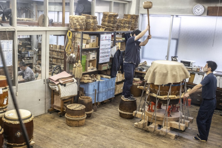 Manual craft: Craftspeople renovate a Japanese taiko on April 26 at the Miyamoto Unosuke workshop in Tokyo.