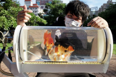 Fish walk: Jerry Huang, maker and fish enthusiast, poses on May 19 with the fish tank trolley he desisgned and built for photographs at a park in Taichung, central Taiwan.