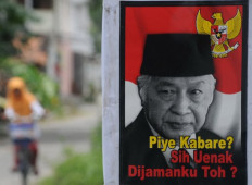 In this photograph taken on March 9, 2014, a poster bearing the portrait of the late Indonesian dictator Soeharto with a slogan, "Hi, how are you? It was better in my time, eh?", is seen in Karanganyar, Central Java.