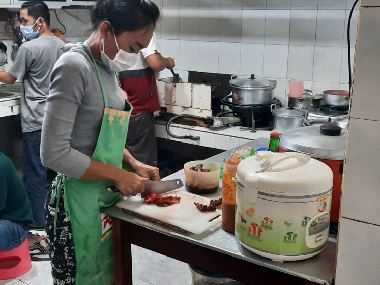 Ready to start: A kitchen worker cutting up red roast pork in Depot Acu Aling, a kopitiam-style establishment in Surabaya's Chinese Quarter. (JP/Raka Ibrahim)