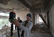 French engineer and specialist in 3D data acquisition Emmanuel Durand uses his laser-scanner in Kharkiv on May 28, 2022, to map the architecture of the damaged building of the Faculty of Economics of Karazin National University.