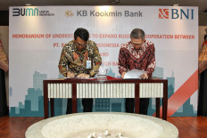 BNI Treasury and International Director Henry Panjaitan, along with Head of the Global Business Group of KB Kookmin Bank and Chief Global Strategy Officer/Senior Managing Director of Kookmin Bank Financial Group Nam Hoon Cho sign the BNI memorandum of understanding with KB Kookmin Bank on Monday (30/5/2022).