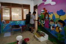 Artists work on a health-protocol themed wall of Kemala Bhayangkari 51 Kindergarten in Tangerang, Banten, on Oct. 10, 2021.
