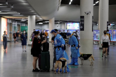 A police officer in a protective suit checks on a commuter at a subway station on June 2, 2022, after the lockdown placed to curb the coronavirus disease outbreak was lifted in Shanghai, China.