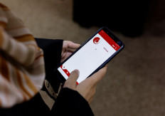 A click away: A Palestinian woman surveys a phone app that supports women who are victims of gender-based violence in Gaza City, Palestine, on Tuesday.