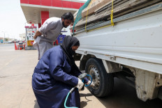 Empowered: Ghada Ahmed checking tire air at an auto quick-service garage in Jeddah, Saudi Arabia, on May 26.