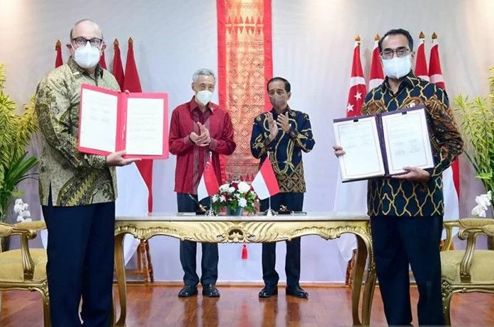 Indonesian Transportation Minister Budi Karya Sumadi (right) and his Singaporean counterpart S. Iswaran show the documents of Jakarta-Singapore Flight Information Region (FIR) Realignment Agreement on Jan. 25, 2022, as former president Joko “Jokowi” Widodo (second right) and Prime Minister Lee Hsien Loong watch, on Bintan Island, Riau Islands.