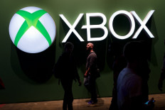 Streaming soon: Game enthusiasts walk past the Microsoft Xbox logo at the Eurogamer Expo 2013 at Earl's Court exhibition center in London on Sept. 26, 2013. Microsoft announced on Thursday that the ability to play Xbox games would be built into Samsung smart televisions in its latest cloud gaming move.