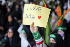 A person holds up a handmade poster while attending a gathering on June 10, 2022 at Tehran University to protest remarks about the Prophet Muhammad made by a top official of India's ruling Bharatiya Janata Party (BJP).