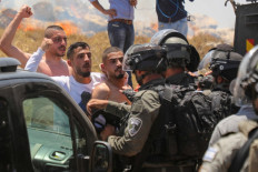 Palestinian demonstrators block the road in front of Israeli security forces during a demonstration against Israeli settlements in the village of Tarqumiya, northwest of Hebron in the occupied West Bank on June 11, 2022. 