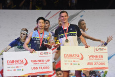 Denmark's Viktor Axelsen (right) poses with his gold medal next to Taiwan's Chou Tien Chen with his silver medal after the men's singles final at the Indonesia Masters badminton tournament in Jakarta on June 12, 2022. 