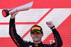 Red Bull's Dutch driver Max Verstappen celebrates with the trophy after winning the Formula One Azerbaijan Grand Prix at the Baku City Circuit in Baku on June 12, 2022. 