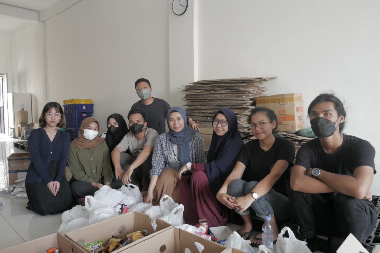 Teamwork: Siti Suci Larasati, founder and CEO of the Aksata Pangan Foundation (fourth from right), is pictured with her team while repackaging potentially wasted food for distribution before it ends up in the garbage. (JP/Tonggo Simangunsong)