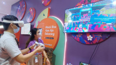 A concert goer at Java Jazz Festival 2022 tries metaverse gear at a BNI stand. BNI introduced a multitude of different digital experiences at the largest jazz festival in Indonesia. 