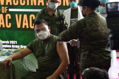 Commanding general of the Philippine army Jose Faustino receives the Sinovac COVID-19 vaccine at the army headquarters in Manila on March 2, 2021. 